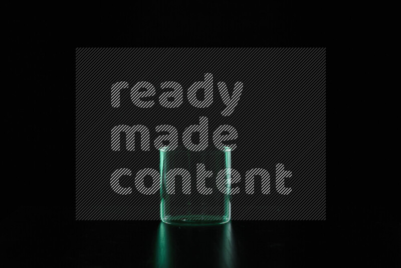 Glassware with rim light in green against black background