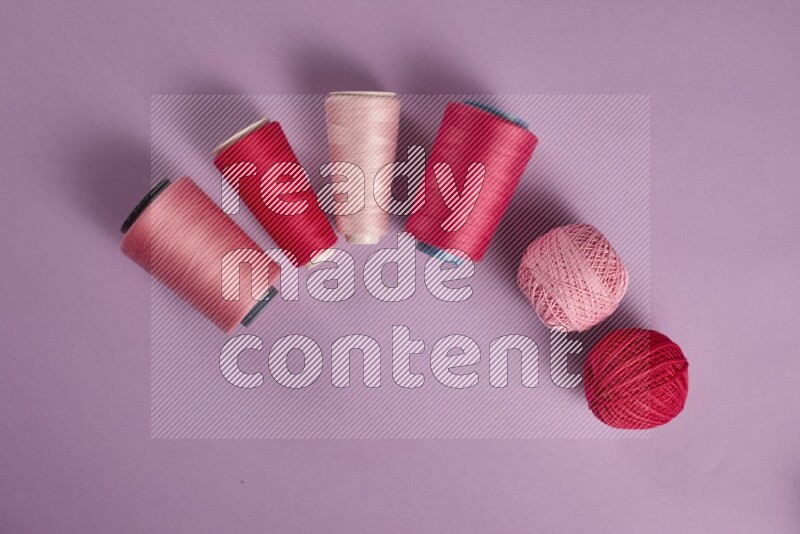 مجموعة من أدوات الخياطة والتفصيل زهرية وأرجوانية اللون على خلفية أرجوانية