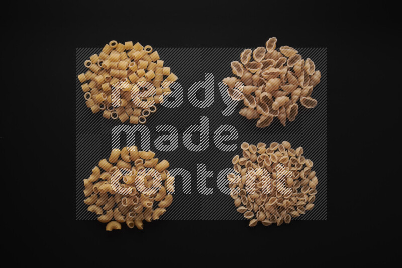 Different pasta types in bunches on black background