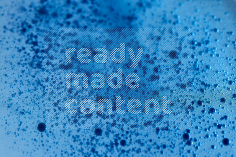 لقطات مقربة لقطرات ألوان مائية زرقاء على سطح الزيت على خلفية زرقاء