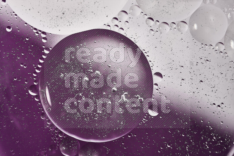 لقطات مقربة لفقاعات من الزيت على سطح الماء باللون الأبيض والأرجواني