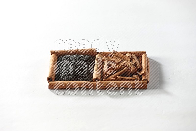 2 squares of cinnamon sticks full of black seeds and cinnamon on white flooring