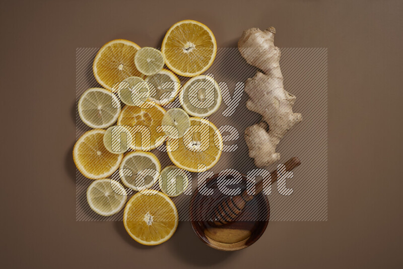 Fresh ginger root with different ingredients such as lemon, orange, honey, ground ginger on beige baackground