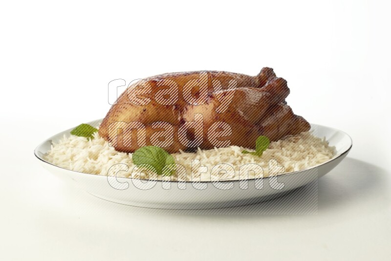 white  basmati Rice with  whole roasted chicken  on a white plate with a silver rim direct  on white background
