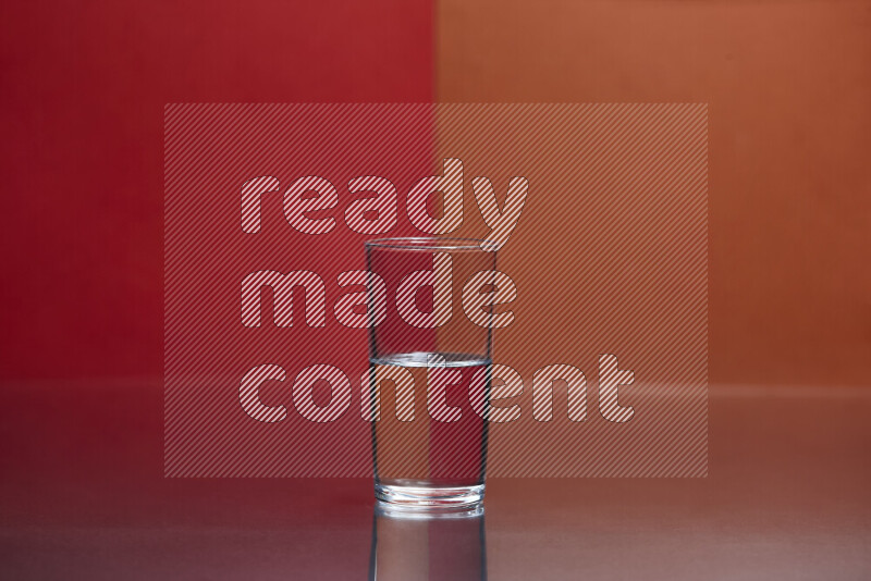 The image features a clear glassware filled with water, set against red and dark orange background