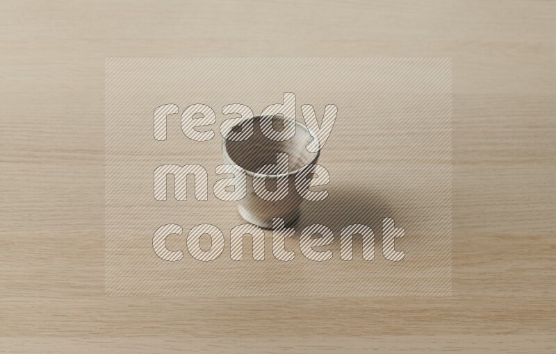 A pottery cup on light wooden background