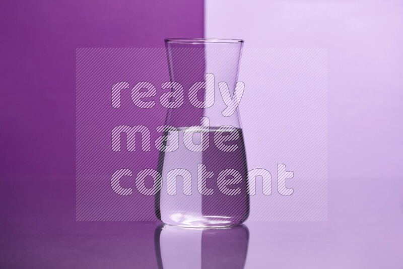 The image features a clear glassware filled with water, set against purple and light purple background