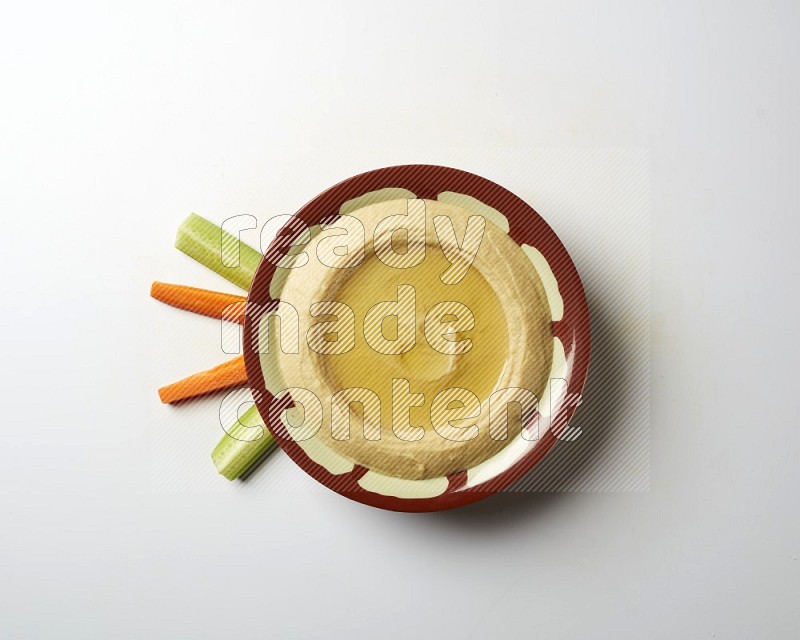 Hummus in a traditional plate garnished with olive oil on a white background