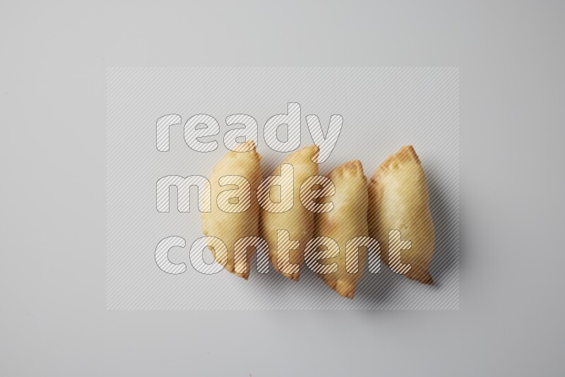Four fried sambosa from a top angle on a white background