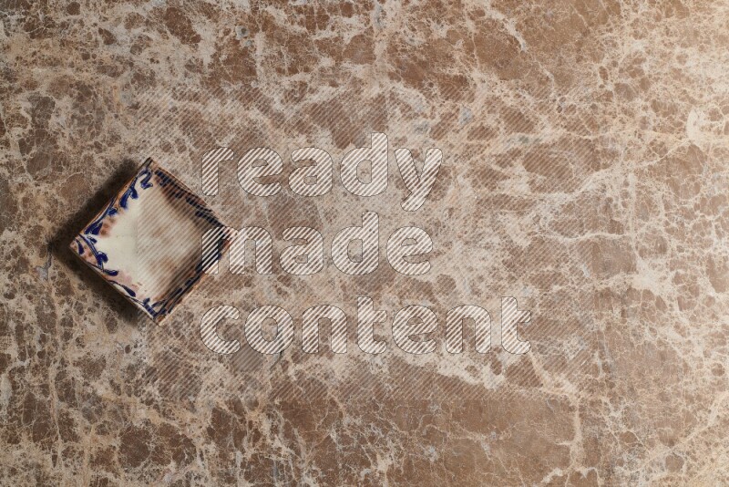 A decorative pottery plate on beige marble background