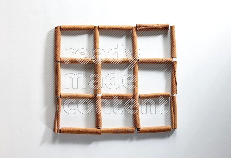 9 empty squares of cinnamon sticks on white flooring