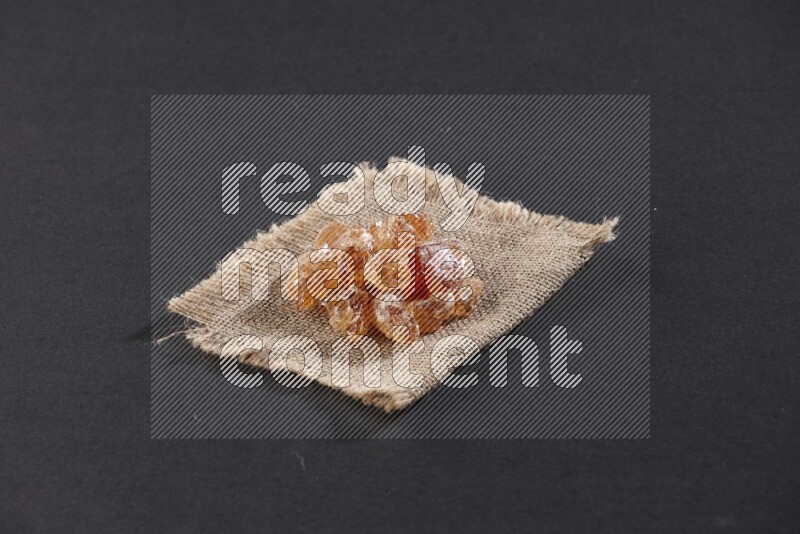 Gum arabic on a burlap piece on black flooring