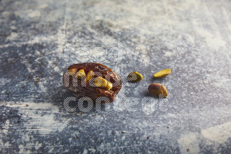 pistachios stuffed madjoul date on a rustic blue background
