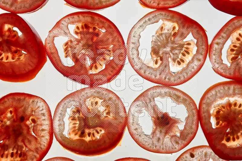 شرائح الطماطم علي خلفية بيضاء مضيئة