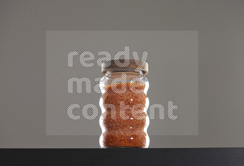 Lentils in a glass jar on black background