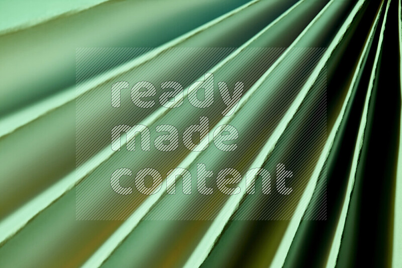 An image presenting an abstract paper pattern of lines in green and gold tones