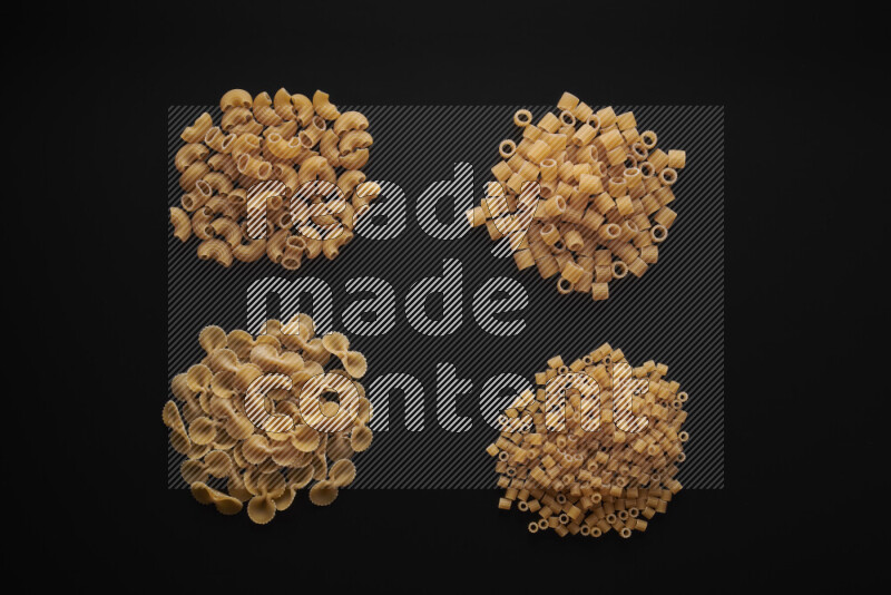 Different pasta types in bunches on black background