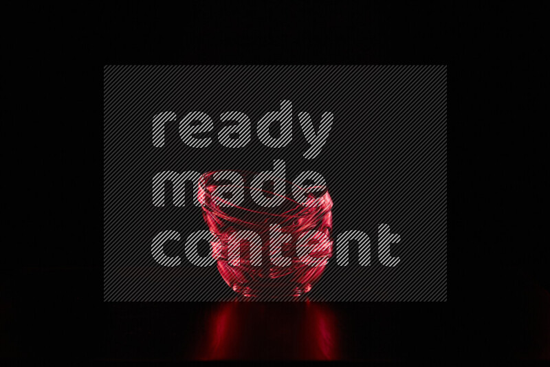 Glassware with rim light in red against black background