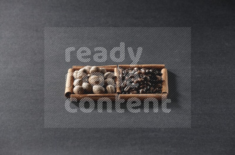2 squares of cinnamon sticks full of coffee beans and nutmeg on black flooring