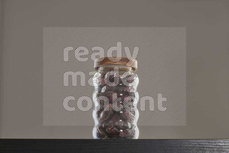 Dates in a glass jar on black background