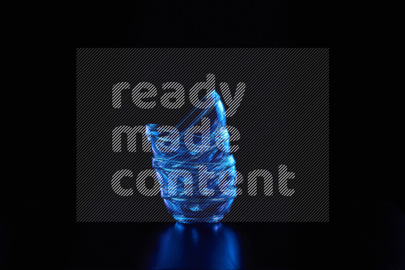 Glassware with rim light in blue against black background