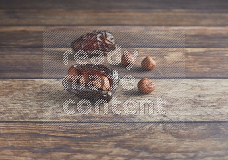 two hazelnut stuffed madjoul date on a wooden background