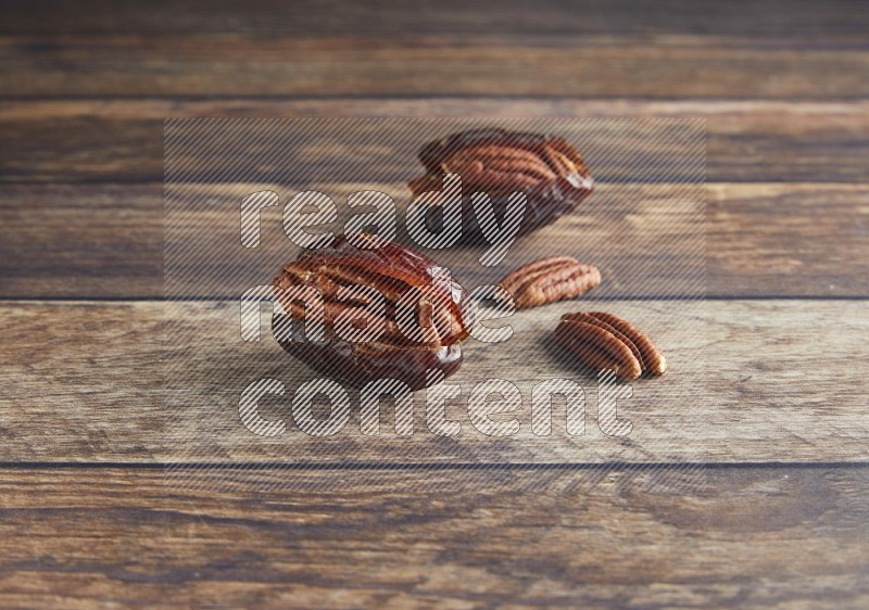 two pecan stuffed madjoul date on a wooden background