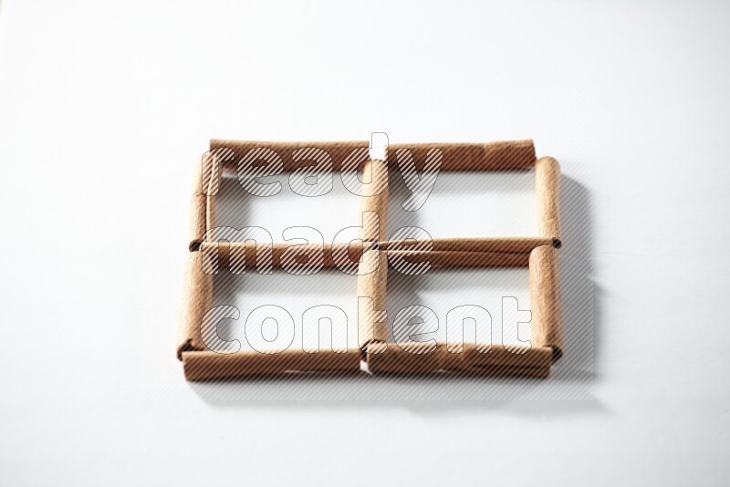 4 empty squares of cinnamon sticks on white flooring