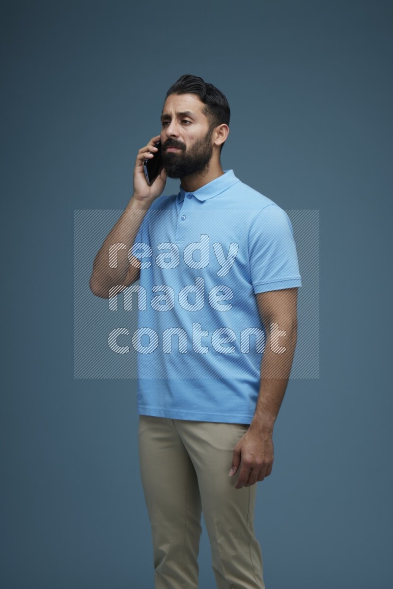 A man having a Call in a blue background wearing a Blue shirt