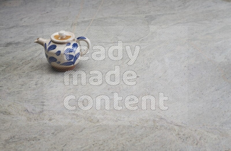 A pottery teapot on grey marble background