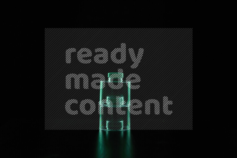 Glassware with rim light in green against black background