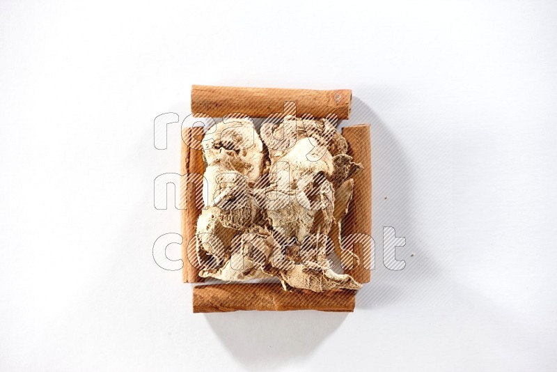 A single square of cinnamon sticks full of dried ginger on white flooring