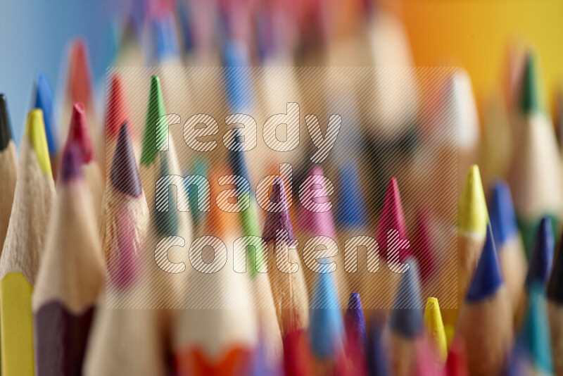The image captures a close-up of sharpened colored pencils on multicolored background