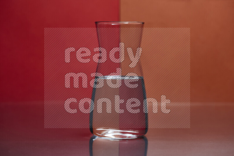 The image features a clear glassware filled with water, set against red and dark orange background