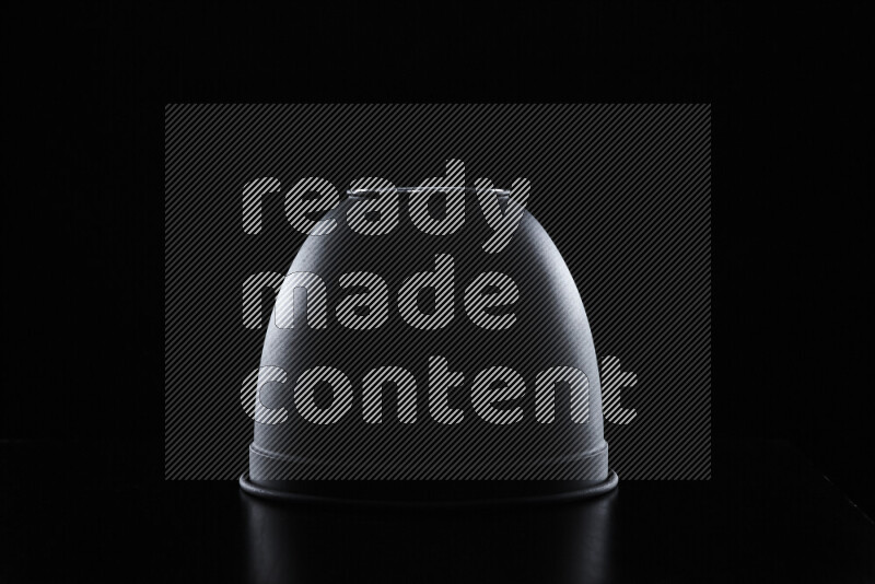 A reflector diffuser lamp shade dish with colored rim light against black background