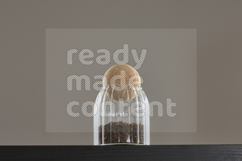Dried basil in a glass jar on black background