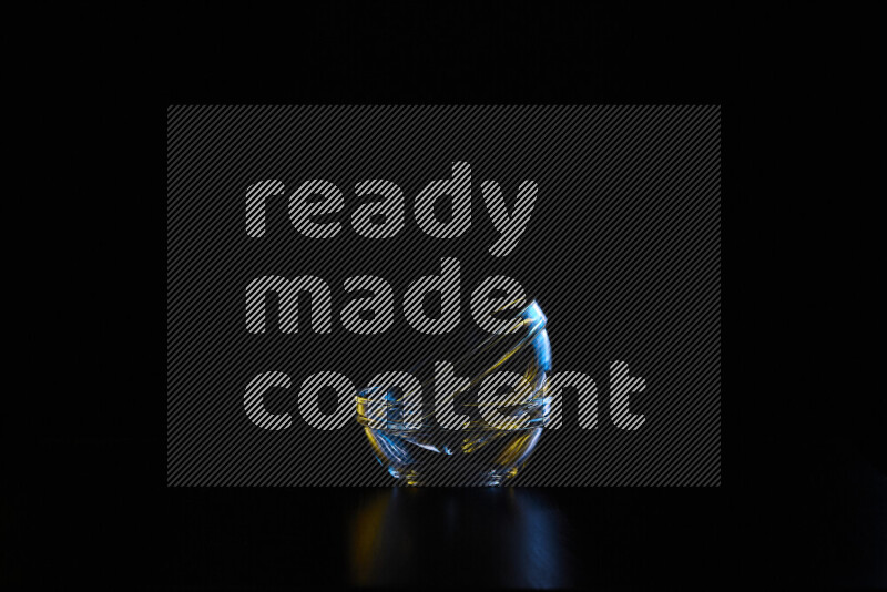 Glassware with rim light in blue and yellow against black background