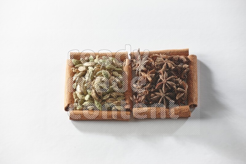 2 squares of cinnamon sticks full of star anise and cardamom on white flooring