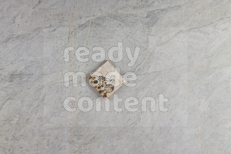 A decorative pottery coaster on grey marble background