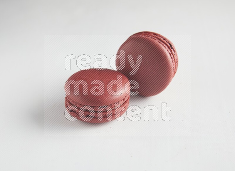 45º Shot of two Red Velvet macarons on white background