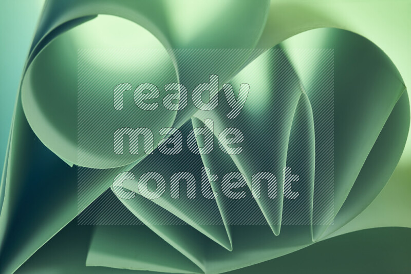 An artistic display of paper folds creating a harmonious blend of geometric shapes, highlighted by soft lighting in green tones