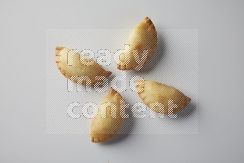 Four fried sambosa from a top angle on a white background