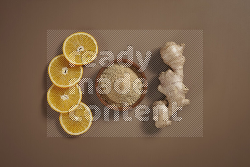 Fresh ginger root with different ingredients such as lemon, orange, honey, ground ginger on beige baackground