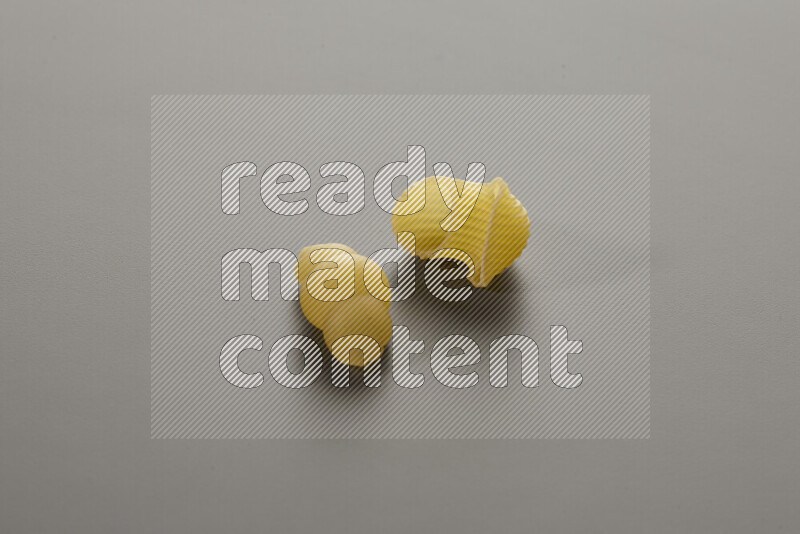 Snails pasta with other types of pasta on grey background