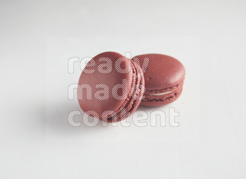 45º Shot of two Red Velvet macarons on white background
