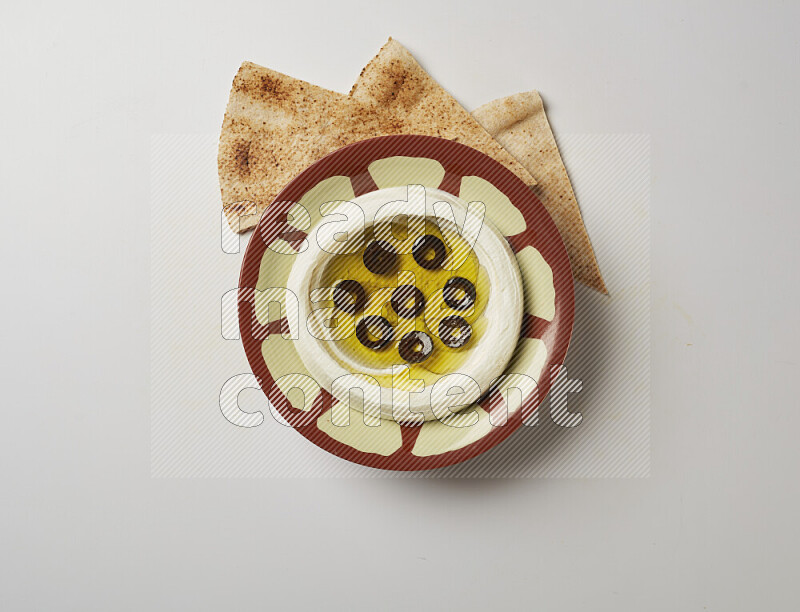 Lebnah garnished with sliced olives in a traditional plate on a white background