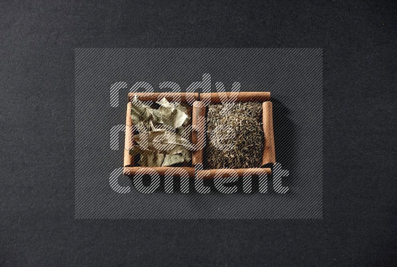 2 squares of cinnamon sticks full of cumin and bay laurel leaves on black flooring