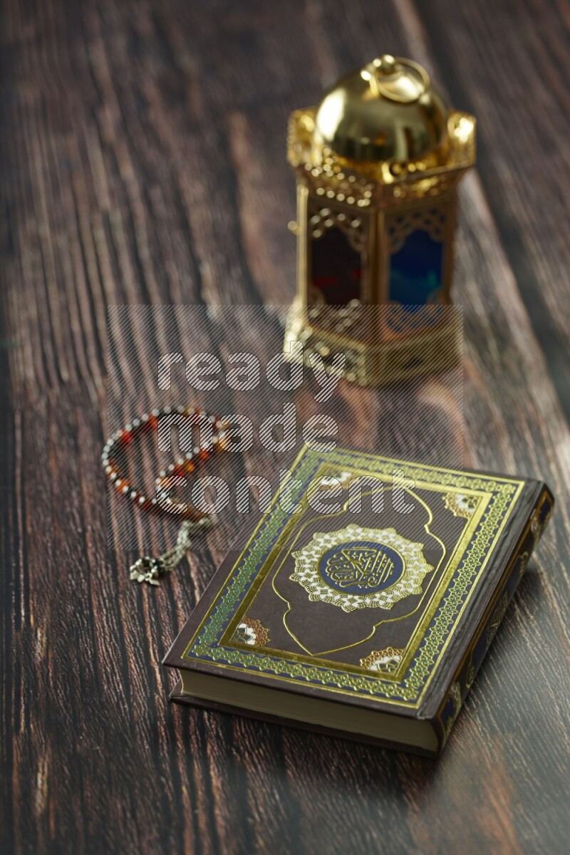 A golden lantern with different drinks, dates, nuts, prayer beads and quran on brown wooden background