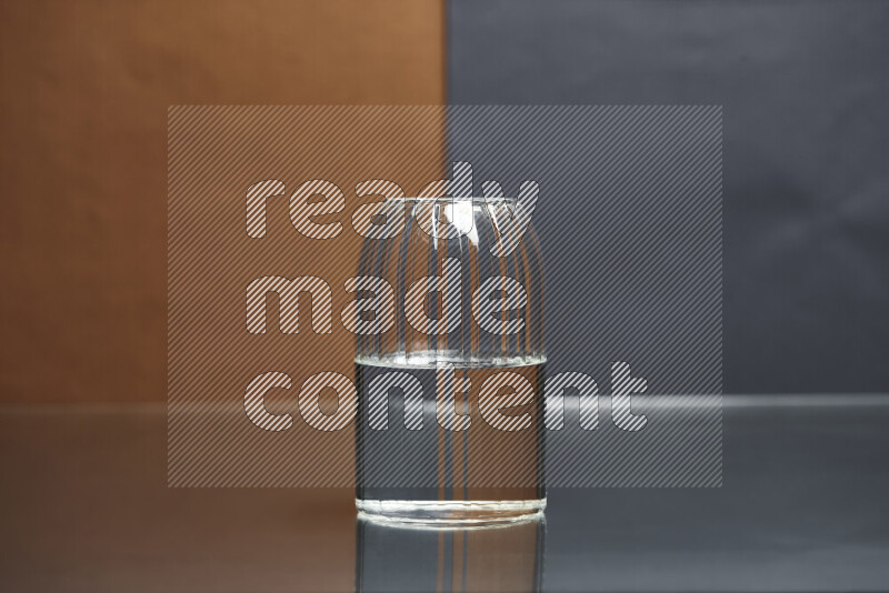 The image features a clear glassware filled with water, set against brown and dark blue background