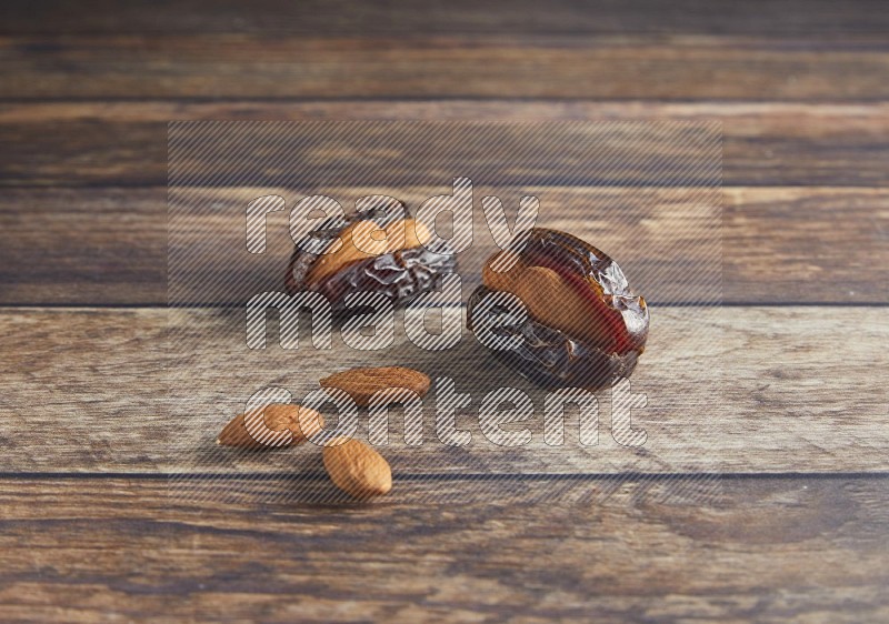 two almond stuffed madjoul dates on a wooden background